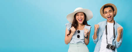 Asian happy young couple tourist preparing for travel with copy space isolated on blue banner background.の写真素材