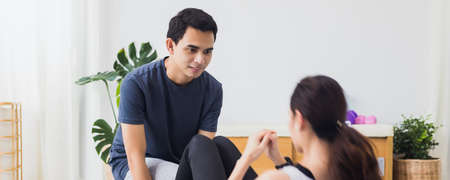 Asian young couple exercise and play yoga together at home background.Concept of Exercise during the...