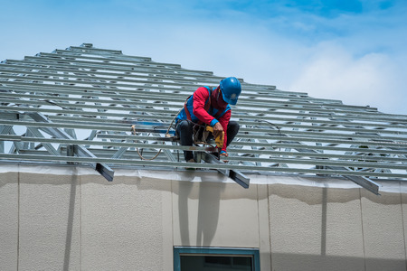 Workers are building a steel roof frame on high.の写真素材