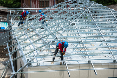 Workers are building a steel roof frame on high.の写真素材