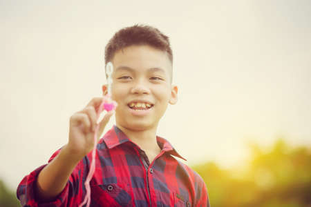 Cheerful a boy blowing soap bubbles in the park, Kids playing conceptの写真素材