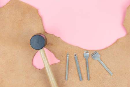 Top view with copy space of leather craft tools group, diamond hole punch and hammer overhead on...