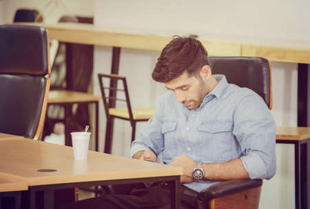 Casual man use mobile smartphone checks social network while take a breakの写真素材