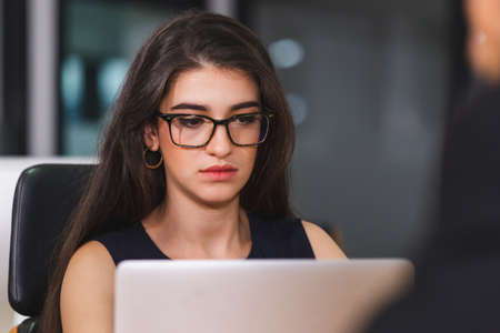 Young business woman in eyeglasses with laptop in meeting roomの写真素材