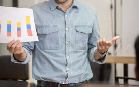 Young business team of coworkers meeting in creative office, businessman standing and holding paper in meeting room, Teamwork conceptの写真素材