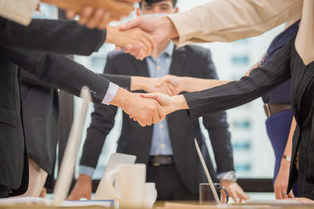 Success and Happiness Team Concept, Businessman and Businesswoman handshake finishing up a meetingの写真素材