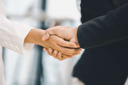 Success and Happiness Team Concept, Businessman and Businesswoman handshake finishing up a meetingの写真素材