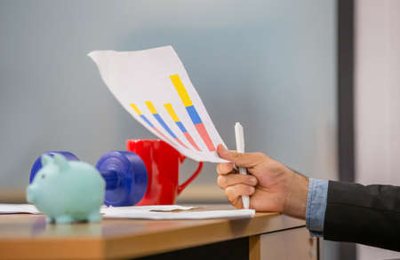 Close up of hand hold paper documents, Businessman holding papers hands in modern coworking office, man reading documentsの写真素材