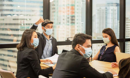 Success and Teamwork concept, Group of young business people wear protection face mask and meeting in officeの写真素材