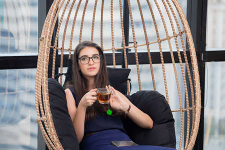 Young Business woman relaxing with holding cup of tea in modern officeの写真素材