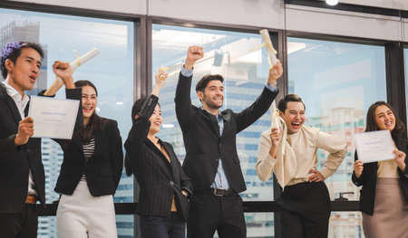Successful team of young perspective business people in office, Success business group celebrating after meeting ( Fake certificate )の写真素材