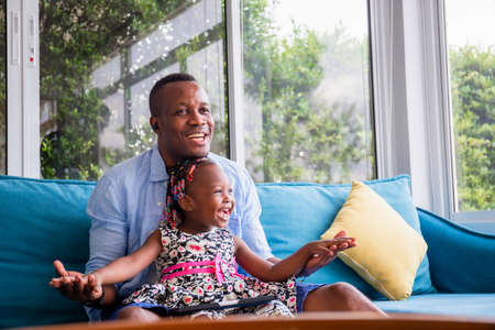 African american father and daughter playing in living room, Happiness family conceptsの写真素材