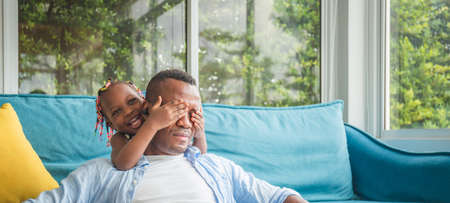 Cheerful african american father and daughter playing in living room, Happiness family conceptの写真素材