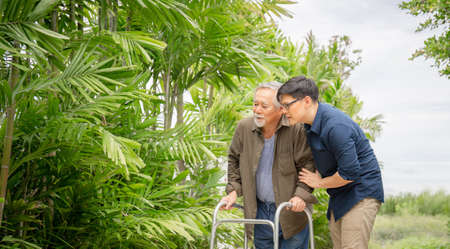 Senior asian father and middle aged son walk in the park, Happiness Asian family conceptsの写真素材