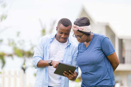 Cheerful african american couple with digital tablet, happiness family conceptsの写真素材