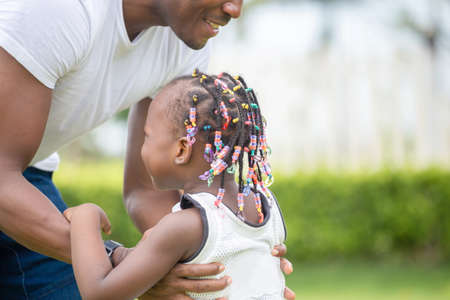 Happy father playing with daughter, Cheerful african american girl playing with her fatherの写真素材