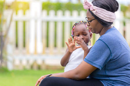 Portrait of african american girl and mother playing together outdoorの写真素材
