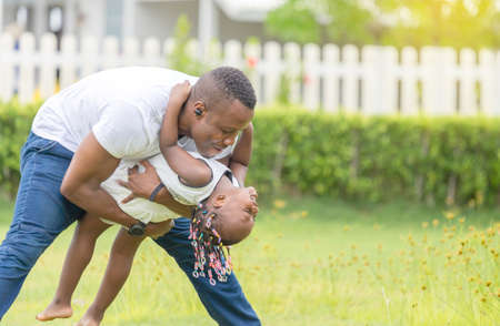 Happy father playing with daughter, Cheerful african american girl playing with her fatherの写真素材