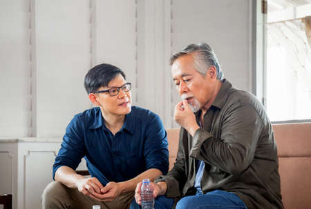 Middle aged son takes care of sick senior father, Happiness Asian family conceptsの写真素材