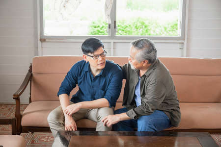Senior asian father give advice adult son in living room, Happiness family conceptsの写真素材