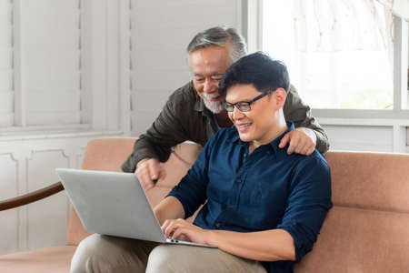 Cheerful asian middle aged son and senior father in living room, Happiness Asian family concepts