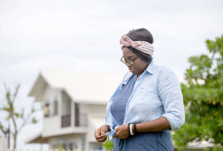 Cheerful african american woman standing and smiling at outdoorの写真素材