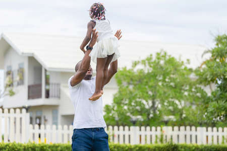 Happy father playing with daughter, Cheerful african american girl playing with her fatherの写真素材