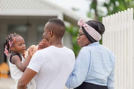 Happiness African american family walking to new house, Father mother and daughter in front of their new homeの写真素材