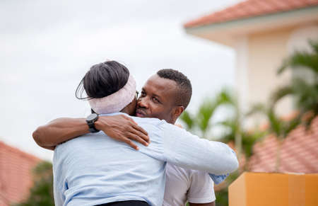 Cheerful african american man hugging girlfriend in their new house, Happiness family and moving day conceptsの写真素材