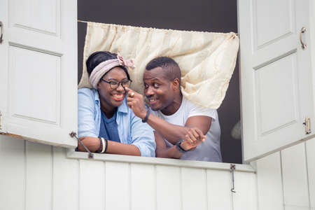 Cheerful african american couple at window, happiness family conceptsの写真素材