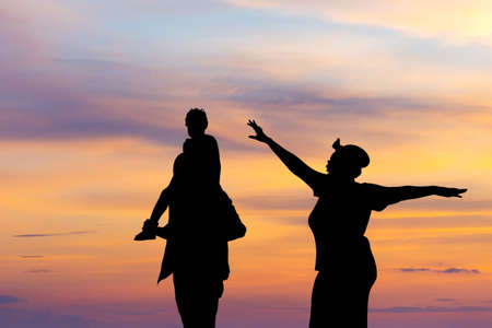 Silhouette of Happy father mother and daughter playing together outdoor, Cheerful family enjoying at sunset, Happiness family conceptsの写真素材