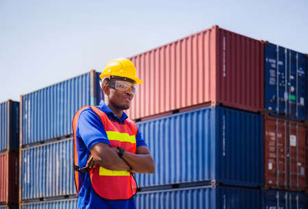 Cheerful factory worker man in hard hat smiling with arms crossed as sign of Successの写真素材