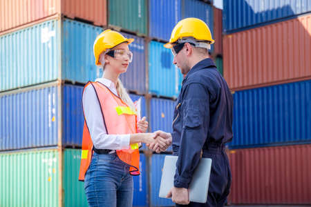 Engineer and worker handshake with blurred containers cargo background, Success and Teamwork concept