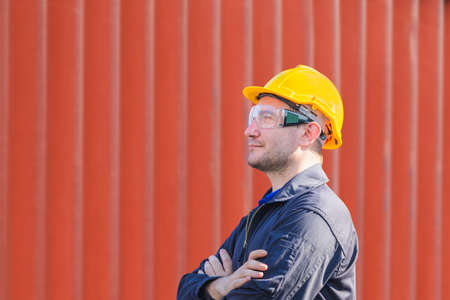 Factory worker man with clipping path smiling with arms crossed on blurred backgroundの写真素材