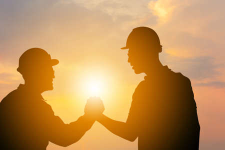 Silhouette of Business engineer man with clipping path handshake evening sky sunset background, Success and happiness team conceptの写真素材