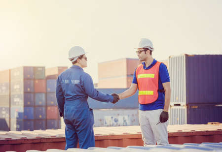 Business engineer man handshake on cargo container evening sky blurred background, Success and happiness team conceptの写真素材