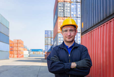 Cheerful factory worker man in hard hat smiling with arms crossed as sign of Successの写真素材