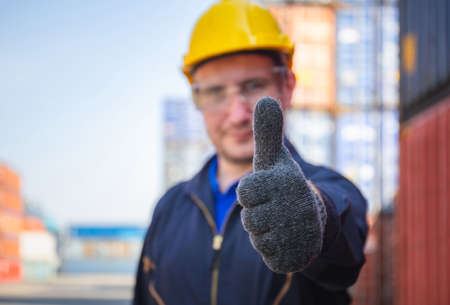 Cheerful factory worker man smiling with giving thumbs up as sign of Successの写真素材