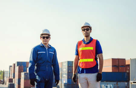 Cheerful factory engineer and worker man in hard hat smiling and looking at sky with joy, Happiness conceptの写真素材