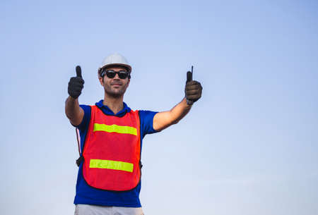 Cheerful factory worker man smiling with giving thumbs up as sign of successの写真素材
