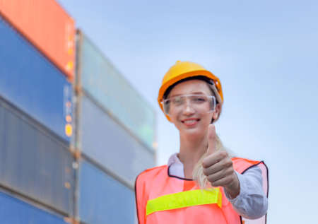 Cheerful female engineer smiling with giving thumbs up as sign of Successの写真素材