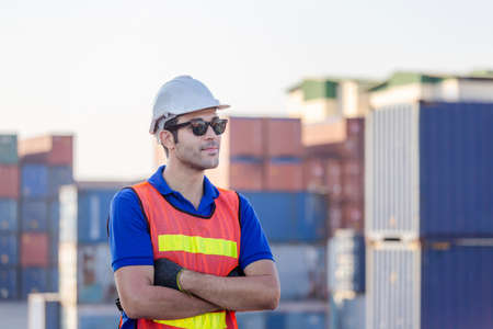 Cheerful factory worker man in hard hat smiling with arms crossed as sign of Successの写真素材