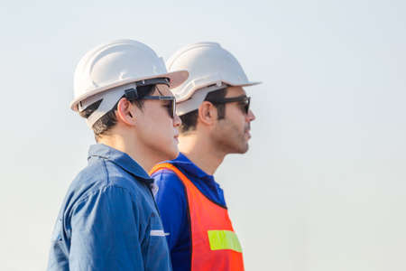 Cheerful female shipping company workers working at the harbor, Engineering man looking to the skyの写真素材