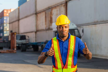 Cheerful factory worker man smiling with giving thumbs up as sign of Successの写真素材