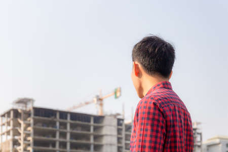 Engineer man checking and planning project at construction site, Man looking into the building siteの写真素材