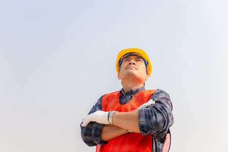 Engineer man checking and planning project at construction site, Man looking into the sky