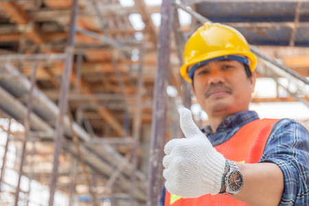 Engineer / worker man hand giving thumb up over blurred construction site, Successful conceptの写真素材
