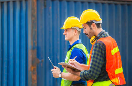 Engineer and worker team checking containers box from cargo with blurred background, Teamwork conceptの写真素材