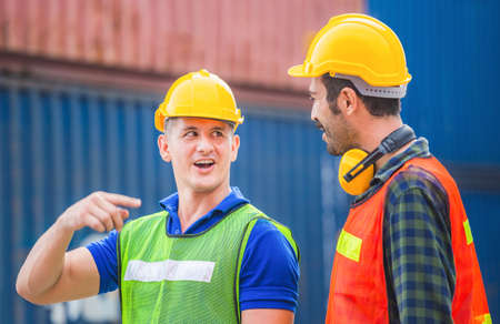Happy Engineer and worker team checking containers box from cargo with blurred background, Teamwork conceptの写真素材