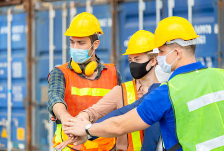 Engineer and factory worker team joining hands at containers cargo, Success Teamwork Concept